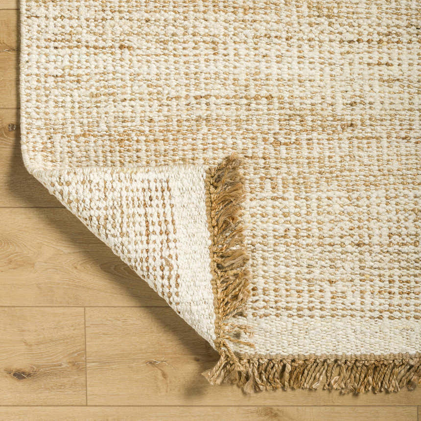 Close-up of the hand-woven Gopi Jute&Wool Area Rug in Cream, showing the jute and wool texture and fringe detail. Fold