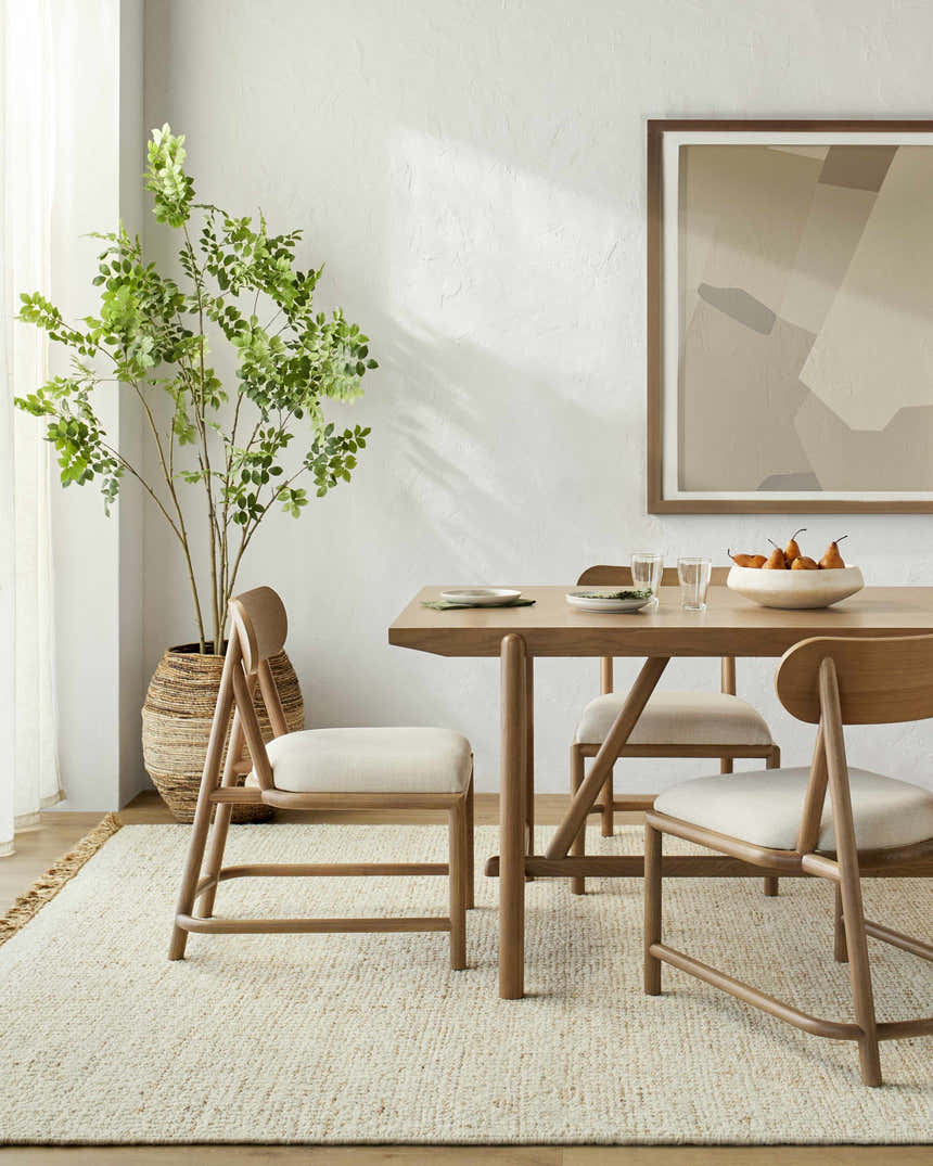 Dining room with a light wood table and chairs on a cream Gopi Jute&Wool Area Rug. Farmhouse style. Roomscene-Rectangle