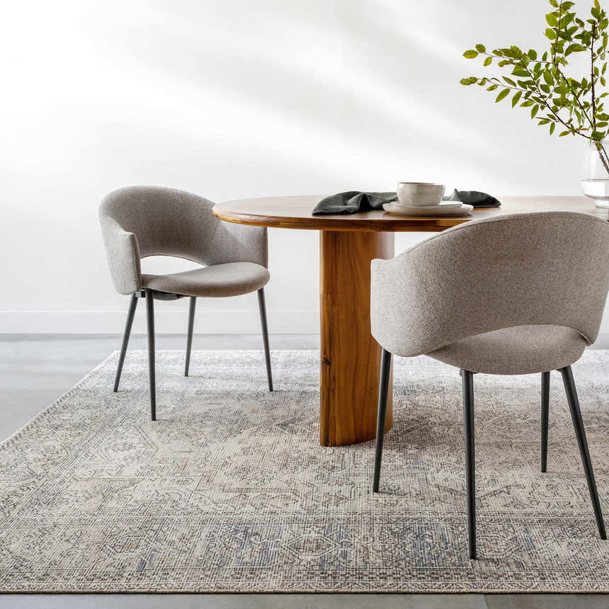 Dining room scene with a round wood table on a Margot Medallion Light Gray rug. Gray chairs and a vase with greenery complete the look. Roomscene-Rectangle
