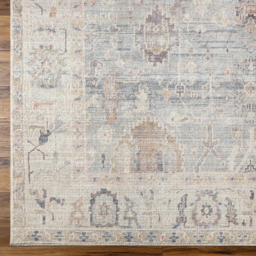 Close up of the Marlene Damask Cream & Blue Area Rug showing its traditional pattern and neutral color palette. Corner
