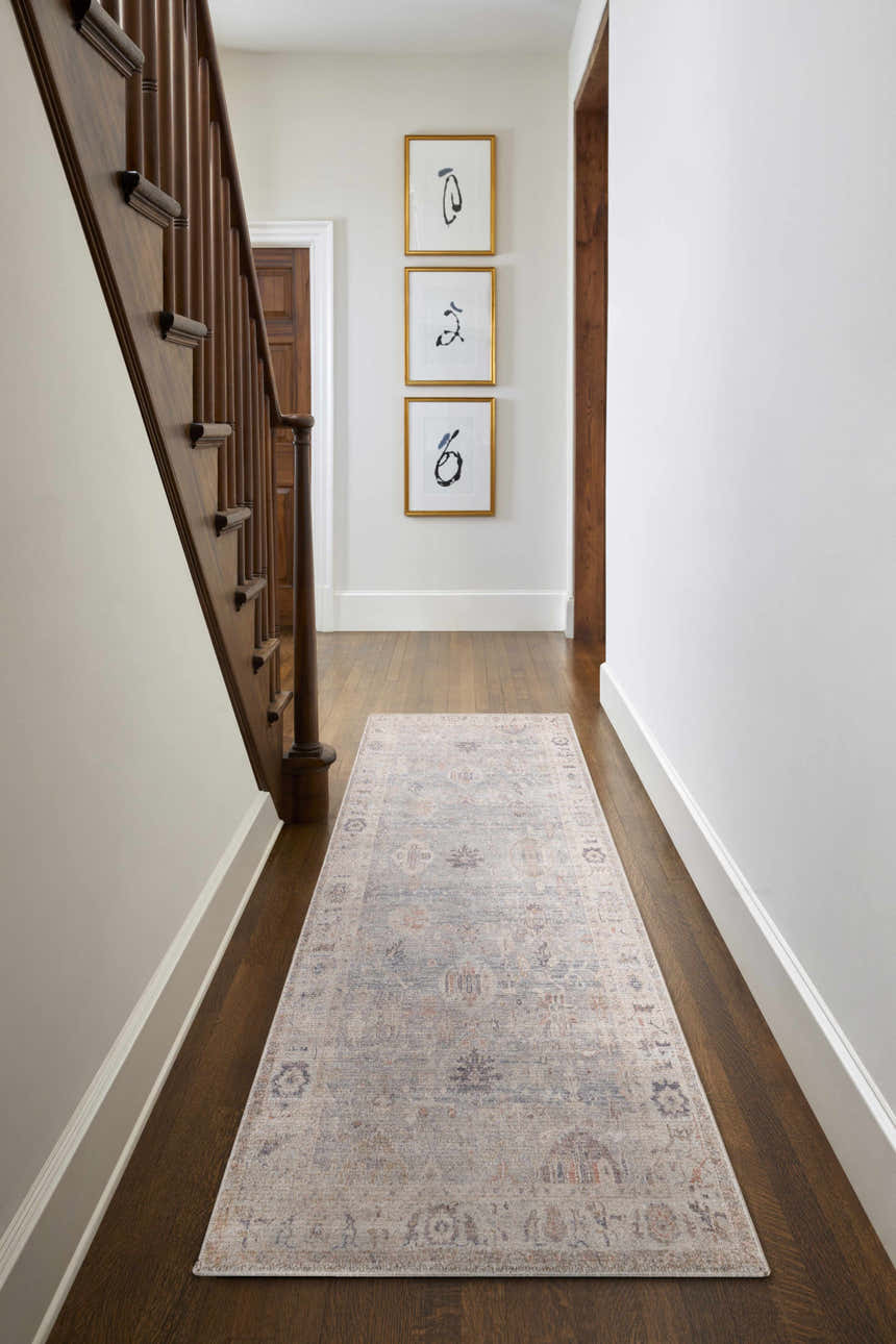 Hallway with wood floors and a Marlene Damask Cream & Blue Area Rug runner, staircase, and framed art. Roomscene-Runner