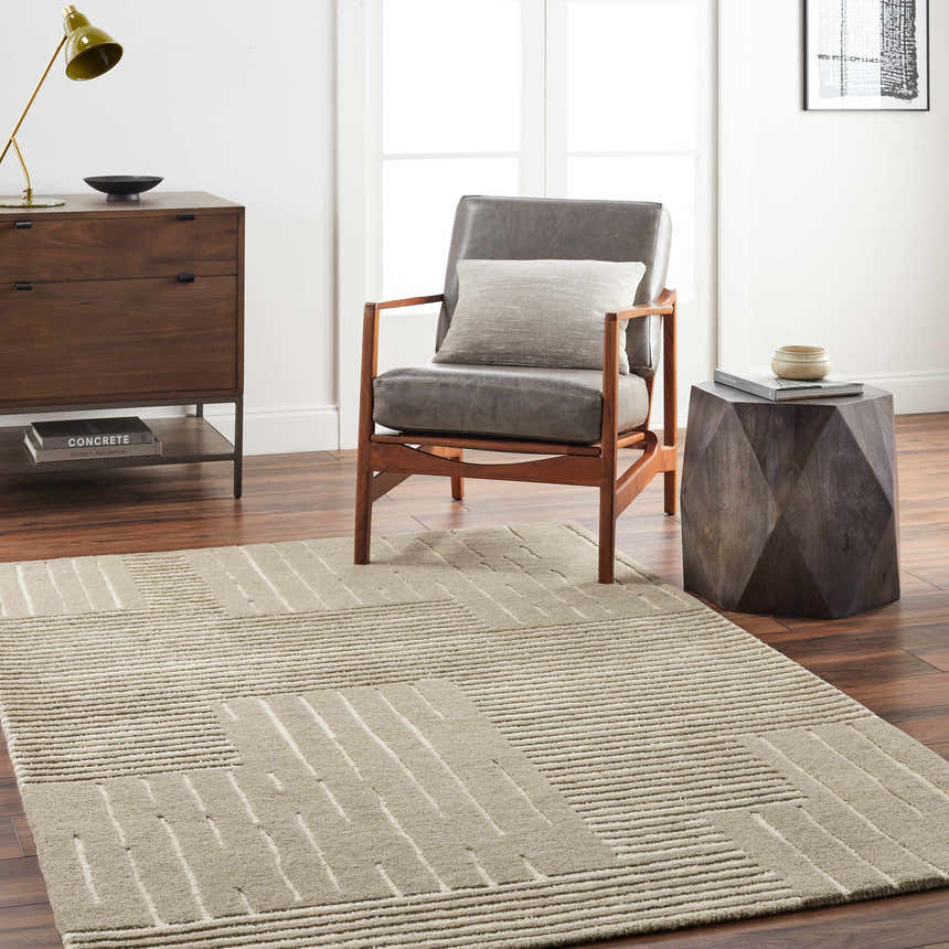 Living room scene with a gray chair, wooden side table, and the Akuji Area Rug in light peach and gray. Roomscene-Rectangle