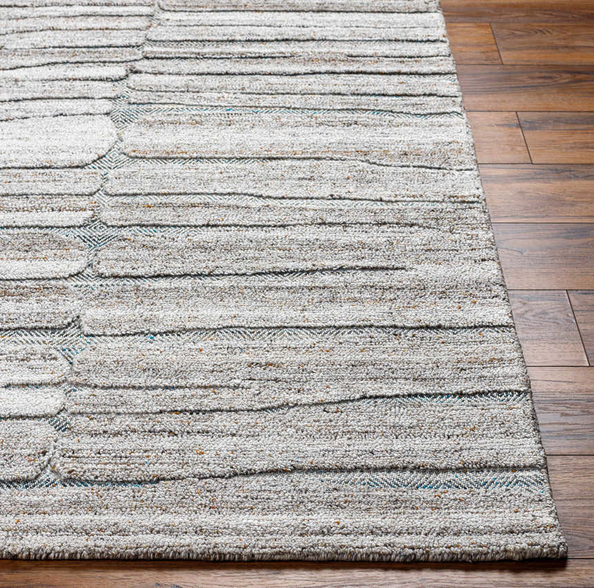 Close up of the hand-tufted Ebba Area Rug. Neutral tones with horizontal stripes and subtle geometric patterns. Recycled PET yarn texture. Front
