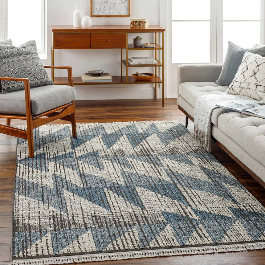 Living room with Zaim Area Rug, a geometric blue and ivory rug, styled with a gray sofa and mid-century modern furniture. Roomscene-Rectangle