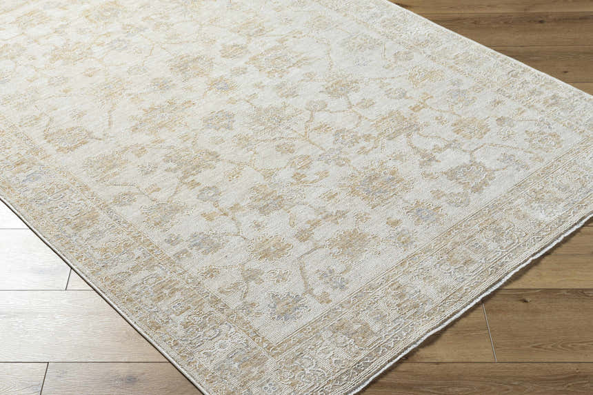 Close-up of the Sashi Tan Luxe Area Rug showing its farmhouse style pattern and tan, light silver, and ash colors. Corner