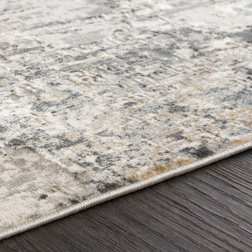 Close-up of the Schaefferstown Area Rug showing its charcoal, gray, beige, and white abstract pattern and soft texture. Texture
