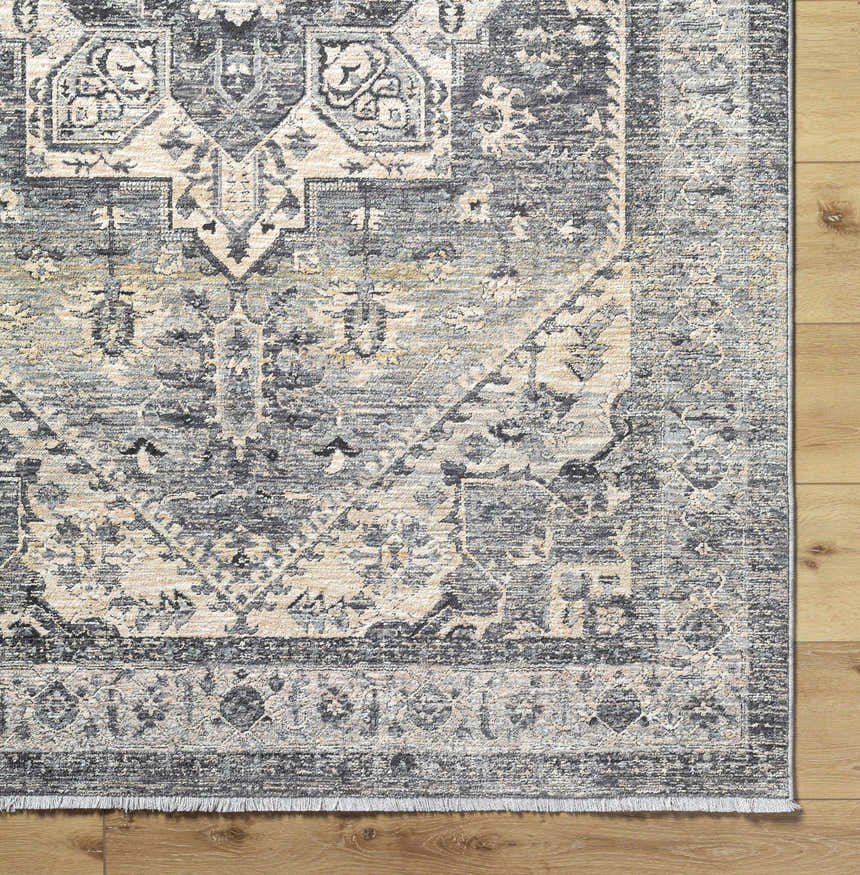 Close-up of the Ailsa Area Rug, a machine-woven polyester rug in dark gray, lambswool, and brown with a traditional pattern. Corner