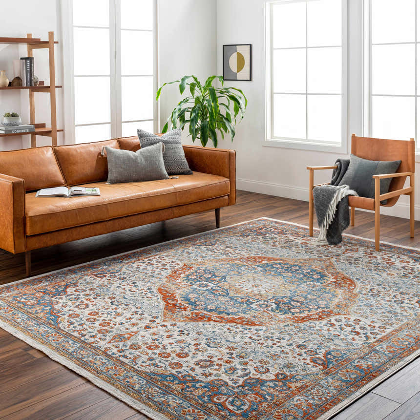 Living room scene with Bojan Area Rug in beachhouse, brown, copper, and denim colors. Traditional rug anchors a modern leather sofa. Roomscene-Rectangle