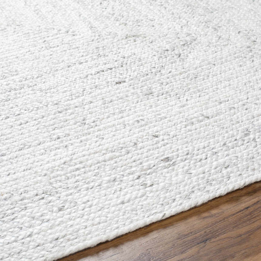 Close-up of the hand woven Kenyi Rose Cream Area Rug, showing its beige and gray pattern and soft texture. Texture
