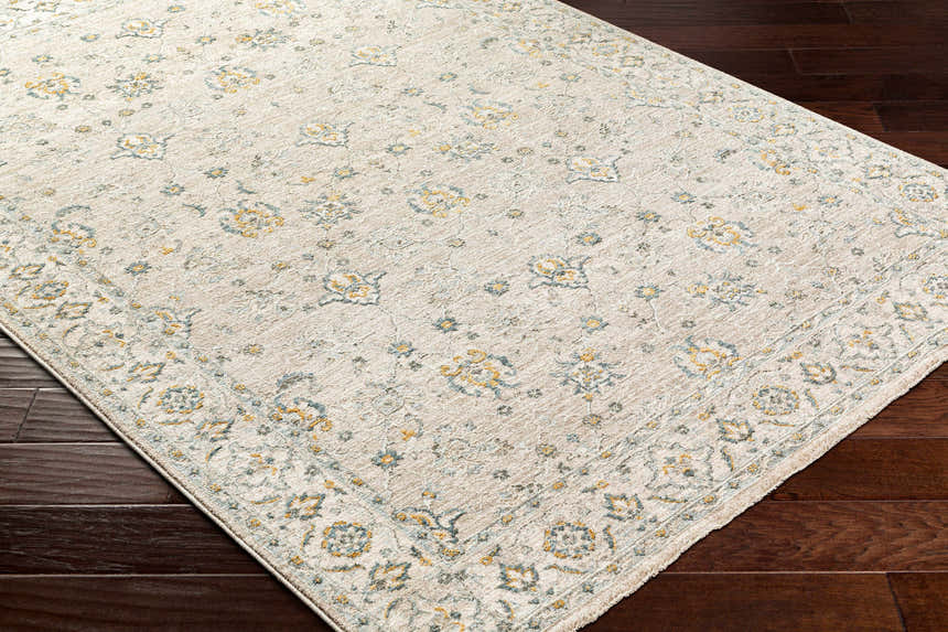 Close-up of Amaru Cream & Sage Textured Rug. Features a traditional floral pattern with sage, cream, and mustard tones. Corner