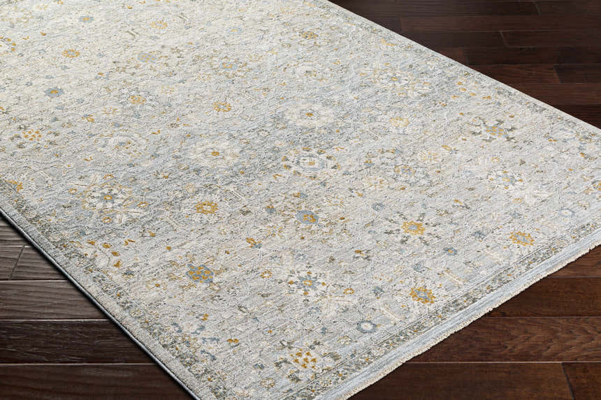Close-up of the Annie Green Textured Rug. Features a floral pattern in shades of green, gold, and blue. Corner
