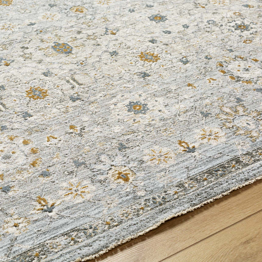 Close up of the Annie Green Textured Rug with Fringes. The rug has a floral pattern in green, gold, and white. Texture