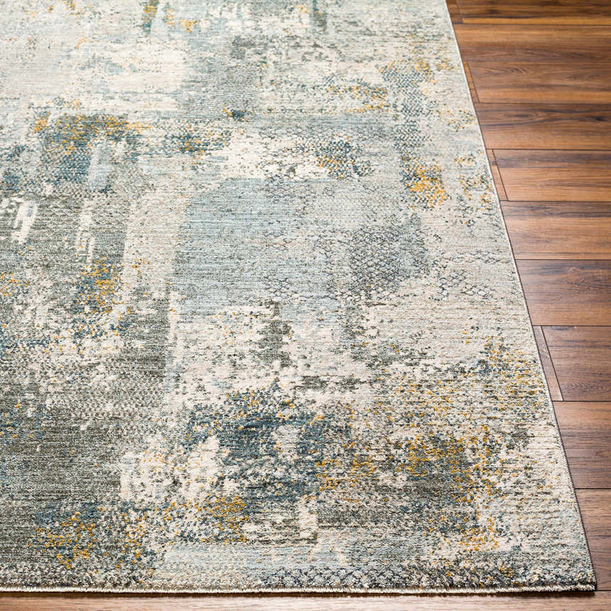 Close-up of Elina Textured Abstract Rug showing dusty sage, ink blue, mustard, and gray tones on wood floor. Front