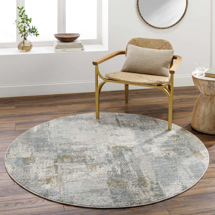 Modern living room scene with a round Elina Textured Abstract Rug in gray, blue, and mustard tones. Roomscene-Round