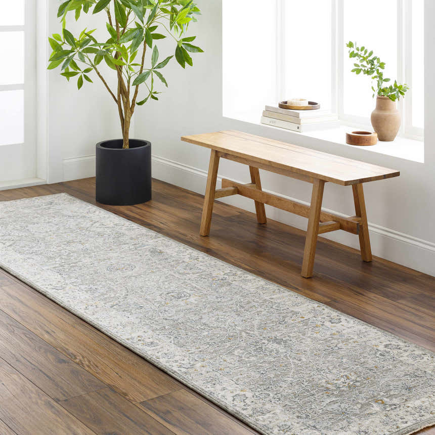 Entryway scene with a Gauge Gray Blue Textured Rug, wood floors, bench, and potted tree. Roomscene-Runner