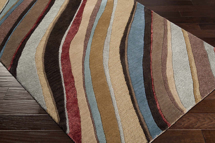 Close-up of Seminole Area Rug with beige, brown, burgundy, and teal wavy stripes on a dark wood floor. Corner