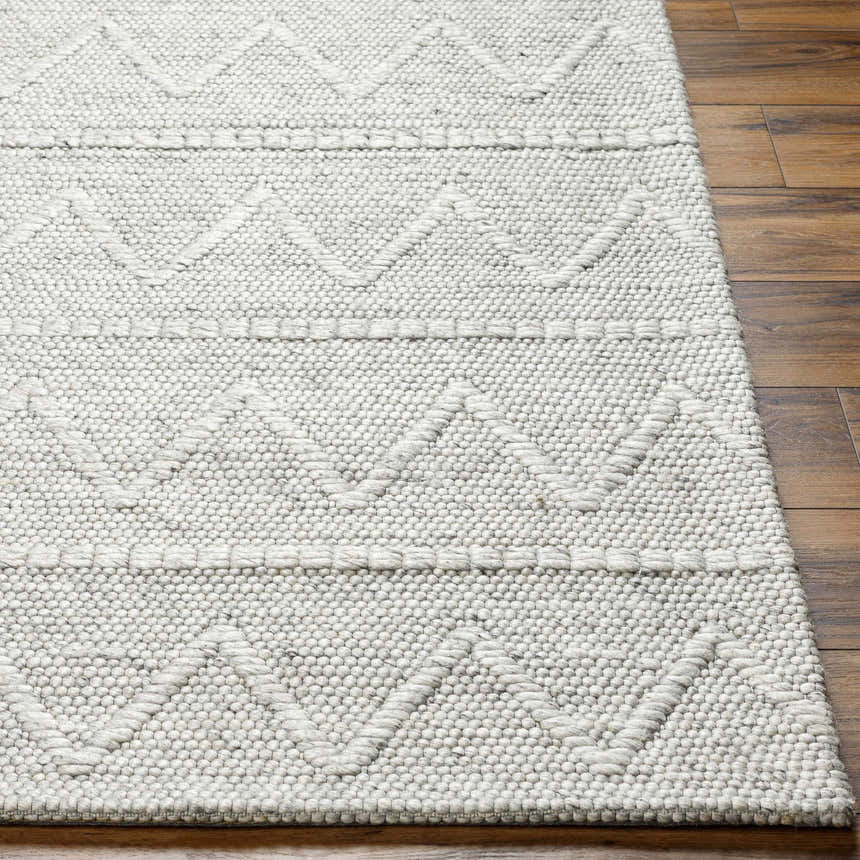 Close-up of Kyung Gray Area Rug showing hand woven texture and geometric pattern on wood floor. Front