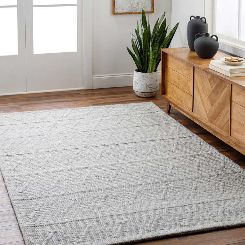 Entryway with the light gray Kyung Area Rug, wood floors, and a mid-century modern cabinet. Roomscene-Rectangle