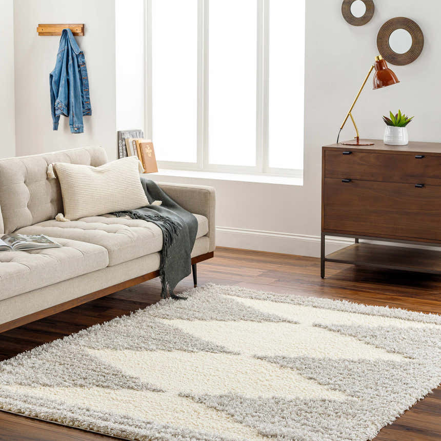 Living room scene with a Bayan Gray Plush Area Rug, beige sofa, wood floors, and mid-century modern decor. Roomscene-Rectangle