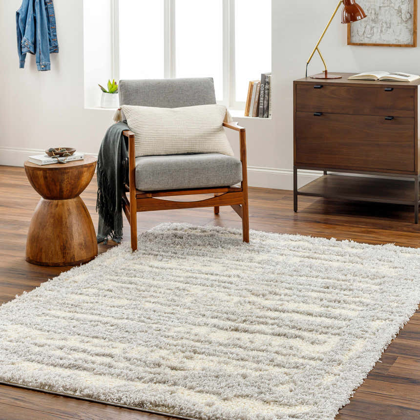 Living room scene with Gidja Gray Plush Area Rug, gray chair, wood side table, and mid-century modern dresser. Roomscene-Rectangle