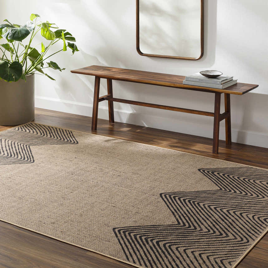 Entryway with Suzy Washable Jutely Rug in camel and charcoal, wood bench, mirror, and potted plant. Roomscene-Rectangle