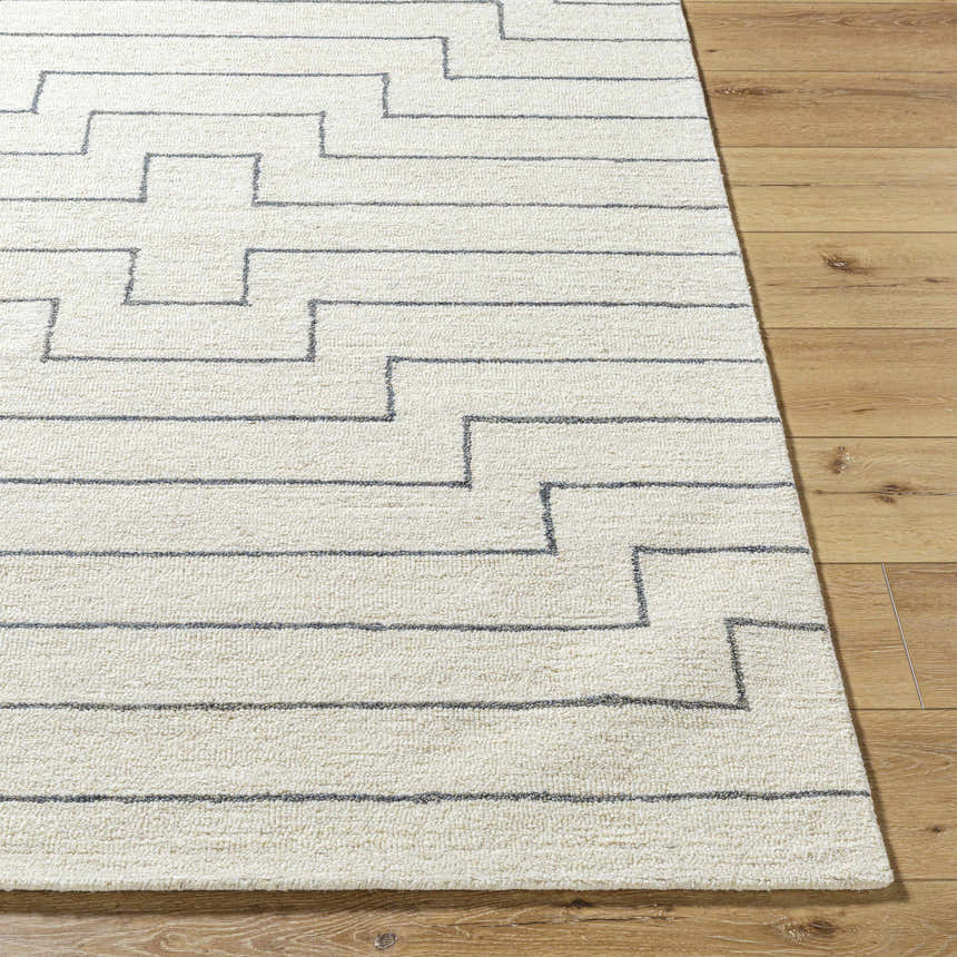Close-up of the hand-tufted Wyome Area Rug. Off-white wool rug with a gray geometric, maze-like pattern. Farmhouse style. Front