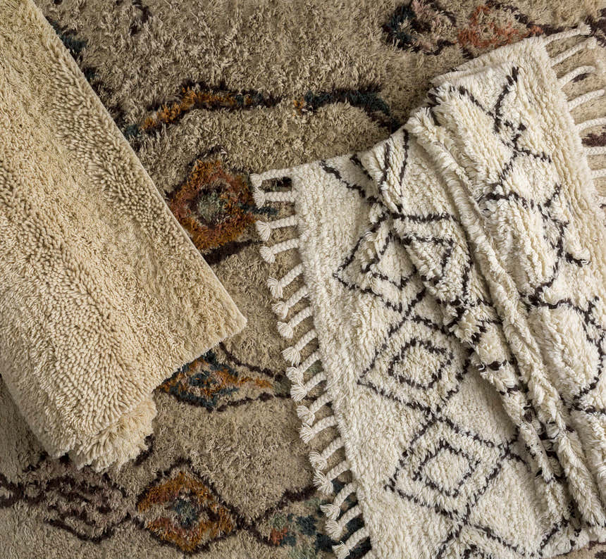 Close-up of Lothian Area Rug showing ivory shag texture, charcoal geometric pattern, and hand woven wool construction. Styleshot