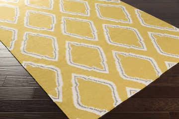 Close-up of Shubert Area Rug. Hand-woven wool runner in cream, gray, and mustard diamond pattern on dark wood floor. Corner