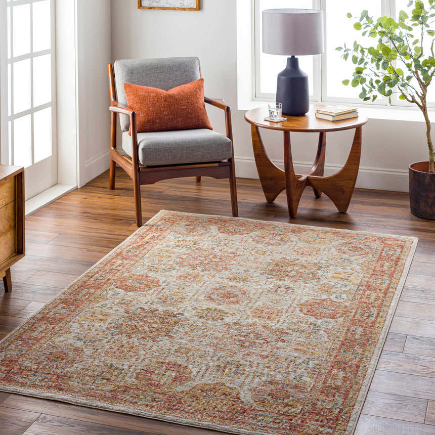 Living room scene with Ange Rust Rich Textured Traditional Rug, gray chair, wood table, and warm, inviting light. Roomscene-Rectangle