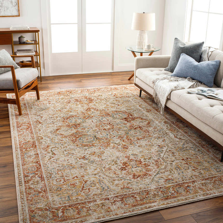 Living room scene with a Cress Rust Rich Textured Traditional Rug, sofa, chair, and wood floors. Roomscene-Rectangle