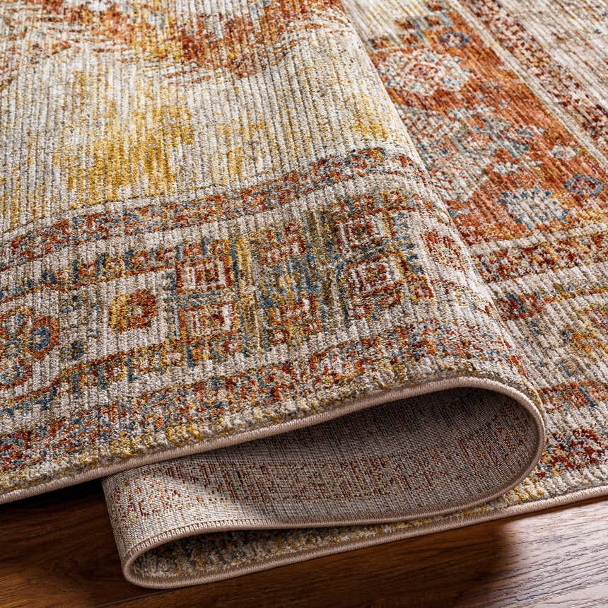 Close-up of the Moya Tan Rich Textured Traditional Rug showing bone, clay, brown, and gray tones. Rolled edge detail. Fold