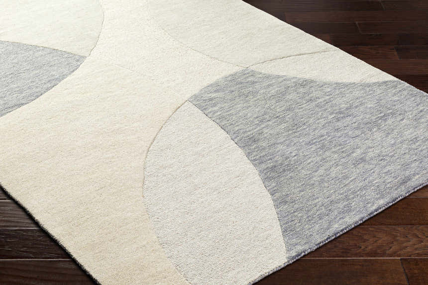 Close-up of the hand-tufted Cassiopeia Gray & Beige Area Rug showing its contemporary geometric design and wool texture. Corner