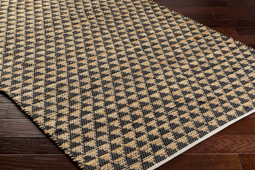 Close-up of the Colm Recycled Black Jean Rug showing its woven texture and geometric pattern in black and beige. Corner