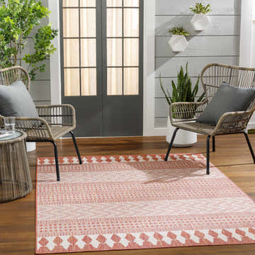 Patio scene with Asif Orange Area Rug, wicker chairs, and potted plants. Farmhouse style, warm and inviting. Roomscene-Rectangle