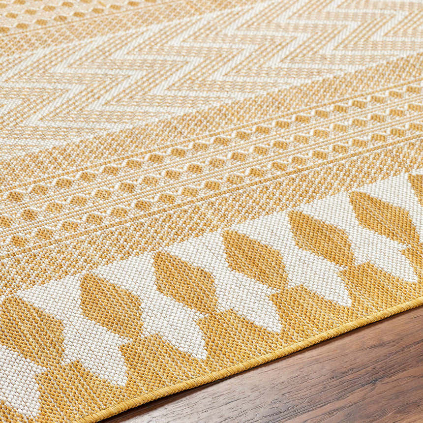Close-up of the Asif Mustard Area Rug showing its geometric pattern in beige and mustard on a wood floor. Texture