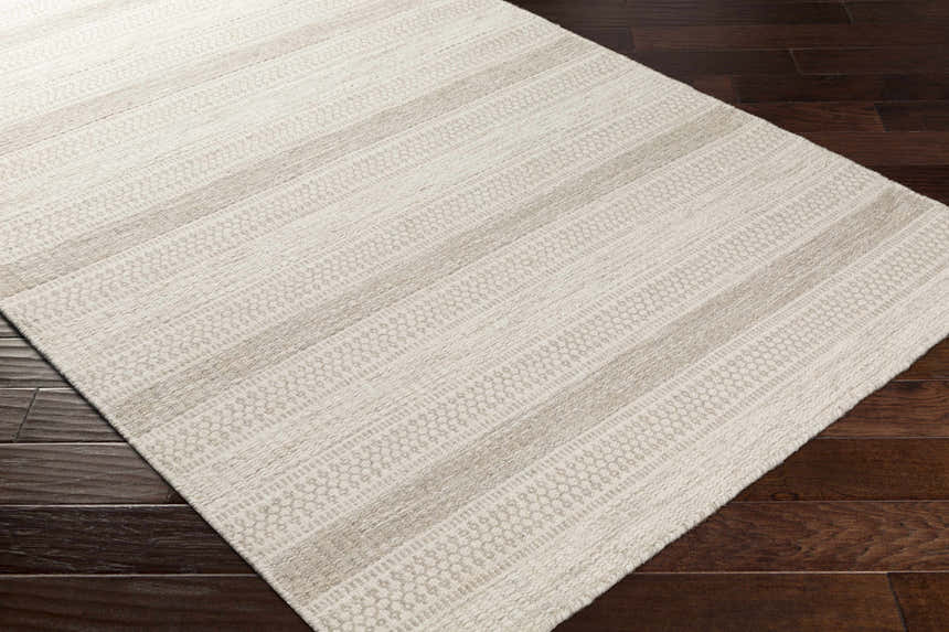Close-up of the hand woven Silverthorne Wool Area Rug. Cream and medium gray stripes and geometric pattern. Corner