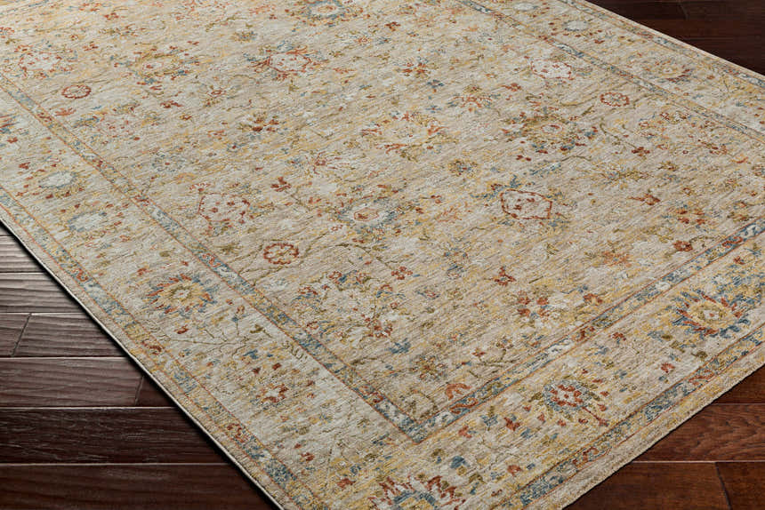 Close-up of the Duong Beige Textured Rug on a dark wood floor. Features a traditional floral pattern in beige, red, blue, and yellow. Corner