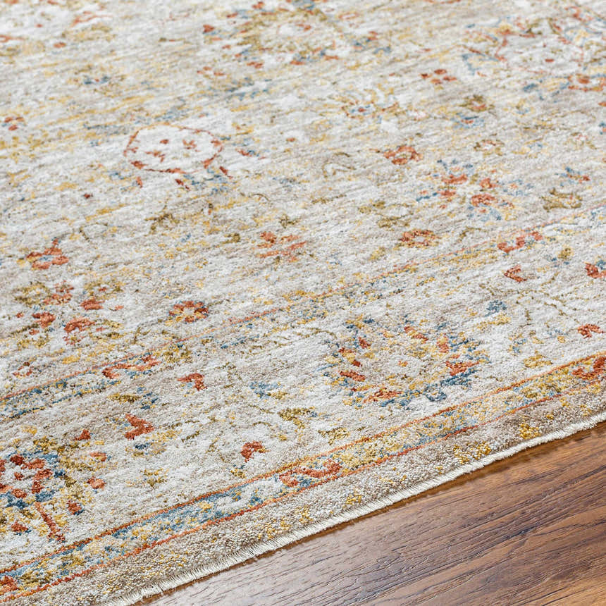 Close up of the Duong Beige Textured Rug with Fringes showing brick red, blue, and mustard floral pattern on a beige background. Texture