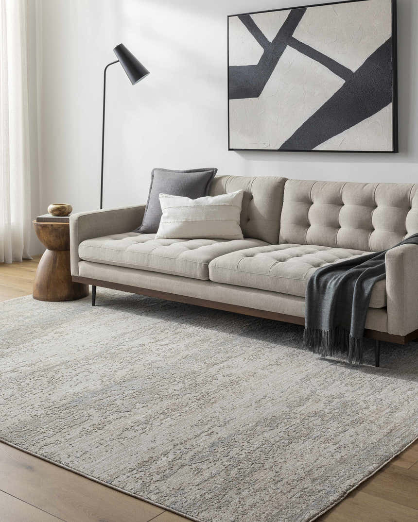Living room scene with a light gray Levon area rug, beige tufted sofa, and modern black floor lamp. Roomscene-Rectangle