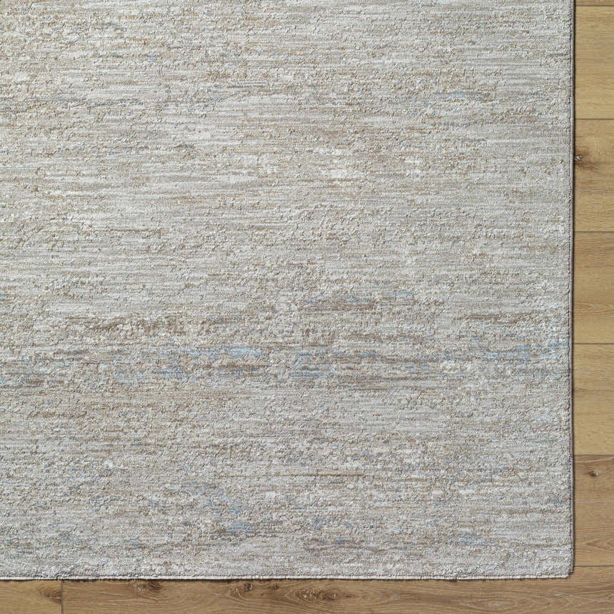 Close up of the light gray Levon Area Rug showing its subtle texture and pattern on a wood floor. Corner