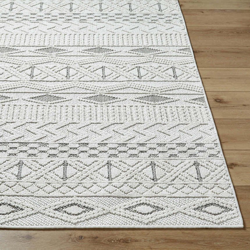 Close-up of the Sokka Area Rug showing its cream and light gray geometric pattern and textured, machine-woven construction. Front