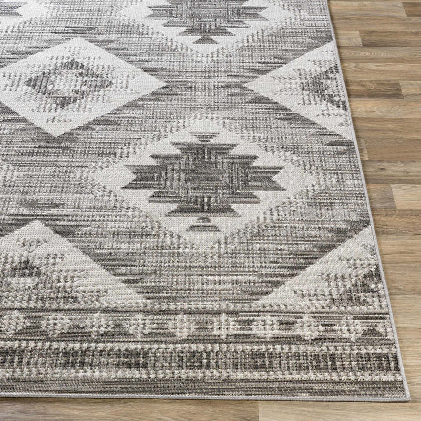 Close-up of the Spade Area Rug. Gray, light slate, and white geometric pattern. Bohemian style. Front