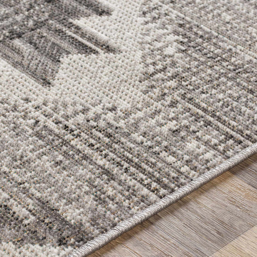 Close-up of the Spade Area Rug. Machine woven texture with a blend of black, light gray, slate, and white tones. Texture