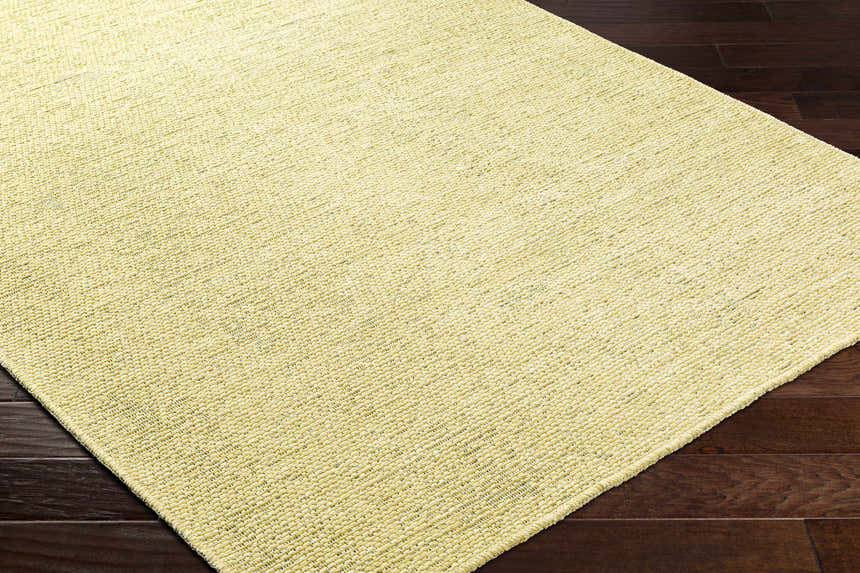 Close-up of the Isako Solid Lime Washable Area Rug showing its textured, woven design and soft lime green color. Corner