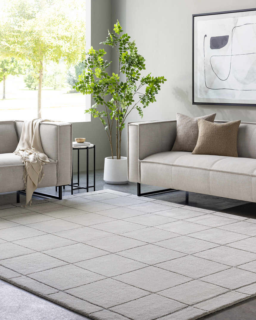 Living room scene with light gray sofas and a Siarl Gray Checkered Area Rug. Modern decor with a tree and neutral tones. Roomscene-Rectangle