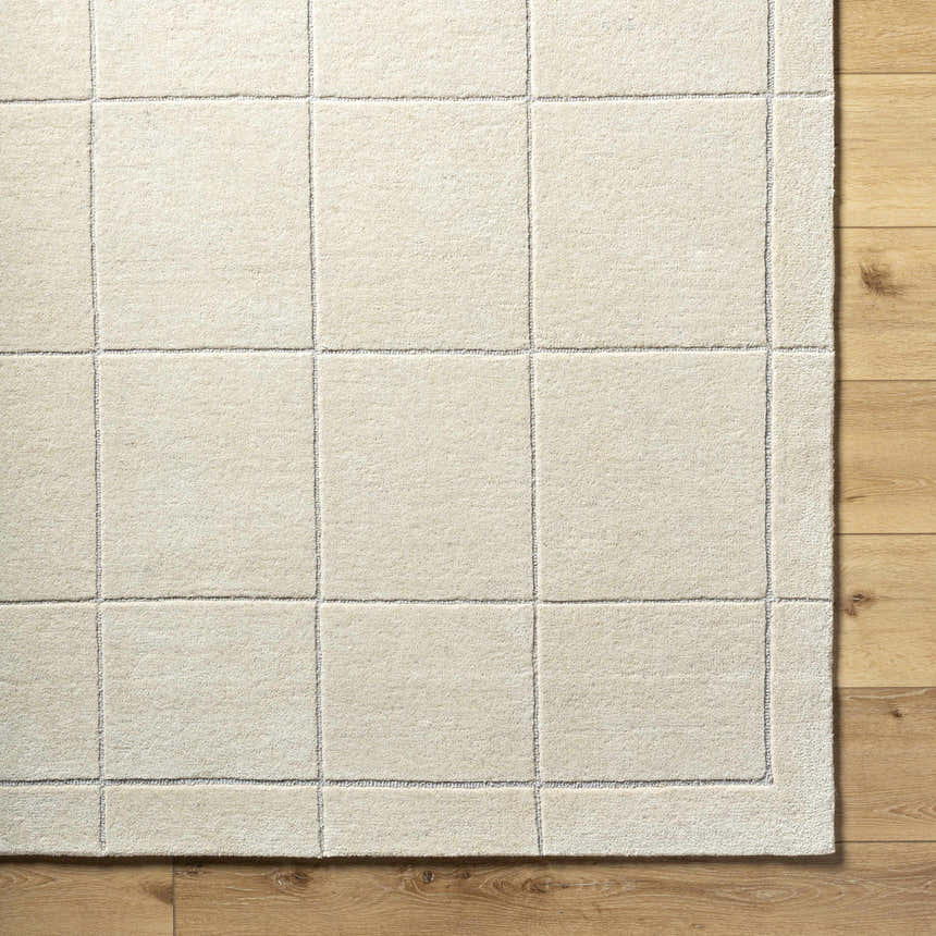 Close-up of a Siarl Cream Checkered Area Rug. Beige wool rug with a simple, contemporary checkered pattern. Corner