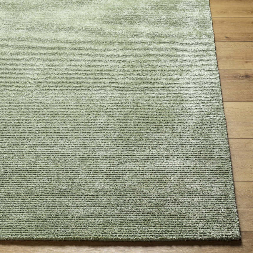 Close-up of the sage Helio Area Rug showing its subtle horizontal texture and soft viscose fibers on hardwood floor. Front