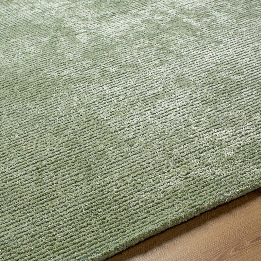 Close up of the sage Helio Area Rug showing its hand tufted texture and subtle linear pattern. Texture