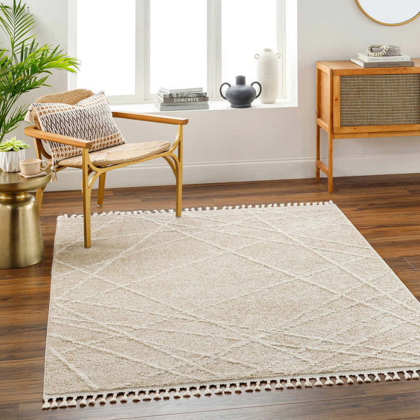 Bright living room with a Hosea Cream Area Rug, chair, and wood accents. Neutral tones create a calming, contemporary space. Roomscene-Rectangle