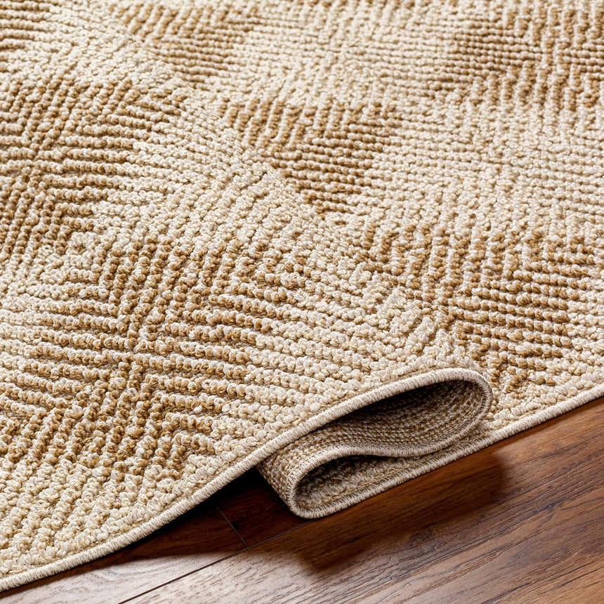 Close-up of the Broox Beige Area Rug showing its textured, geometric pattern and rolled edge on a wood floor. Fold